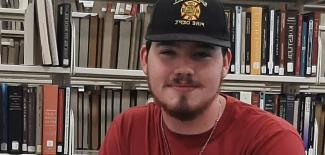 Josh Henley with books behind him